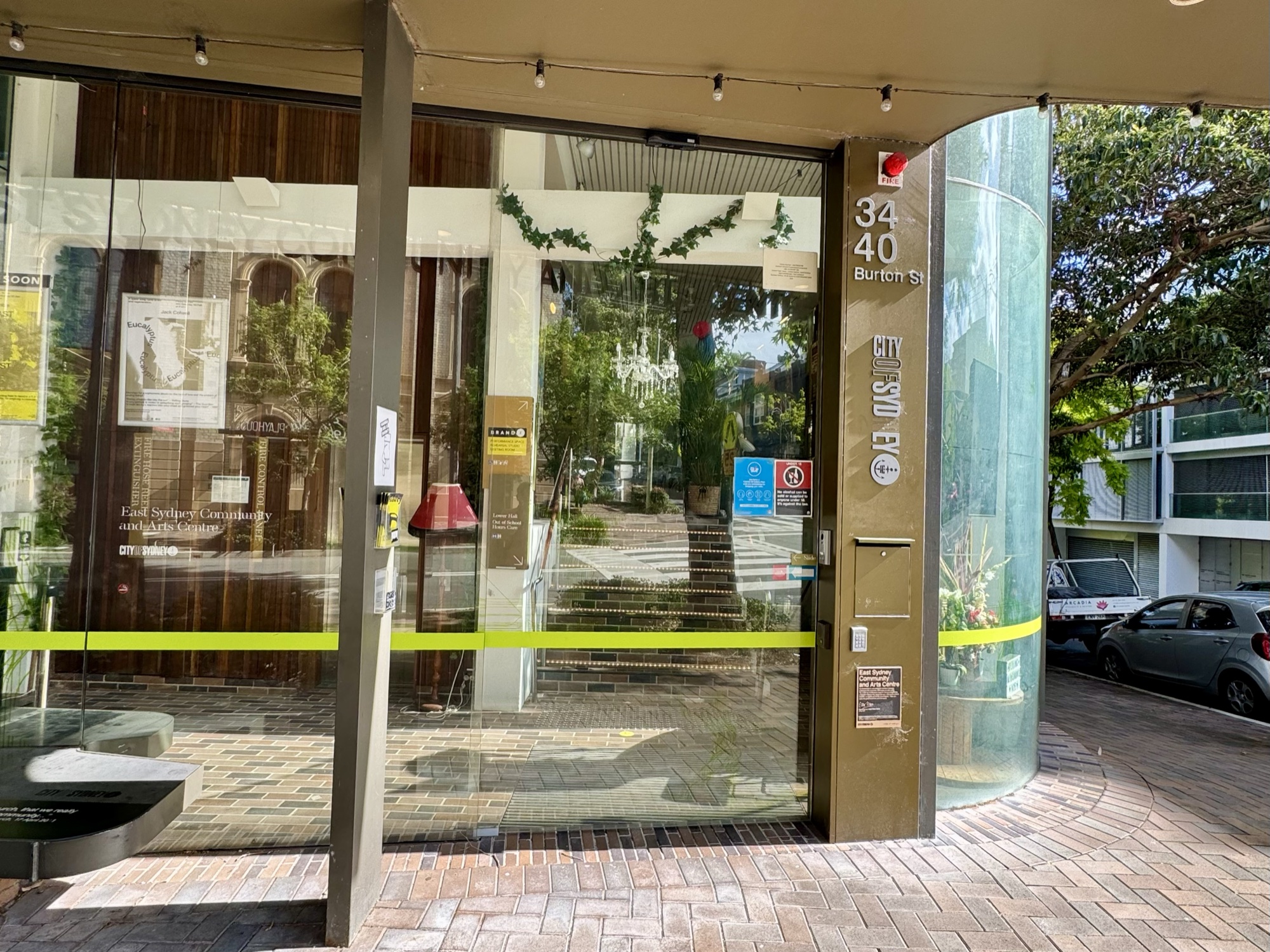 Curved glass entrance doors with the street number 34–40 beside them, on a brick footpath