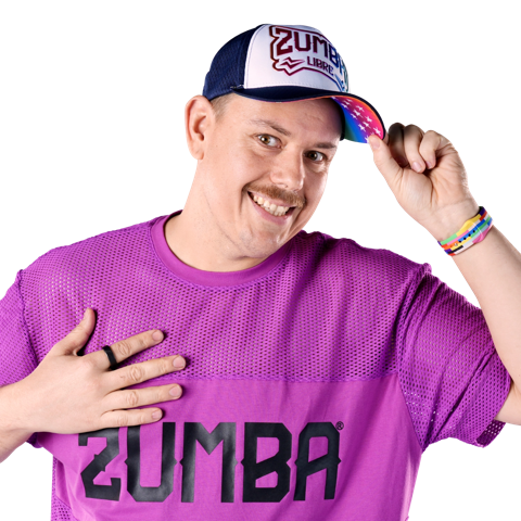 Pawel in a purple Zumba shirt, smiling and tipping his Zumba cap